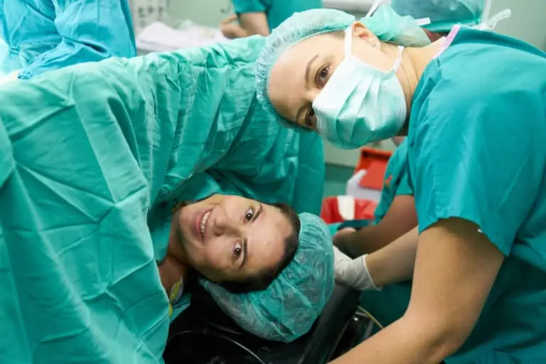 בחורה ורופאה מחייכות למצלמה לפני ניתוח